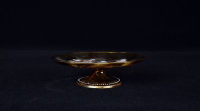 a close up of a gold plate on a black background
