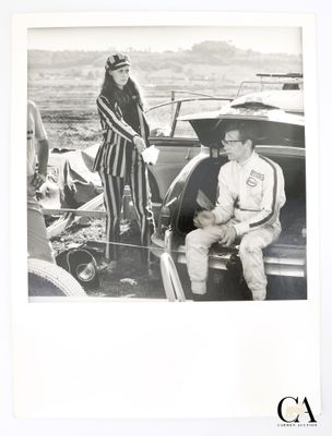 une photo en noir et blanc d'un homme et d'une femme assis dans une voiture