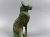 an ancient bronze statue of a cat sitting on its hind legs