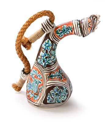 a decorative vase with a rope around it on a white surface