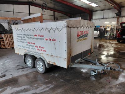une remorque à laquelle est attelée une autre remorque, dans un garage