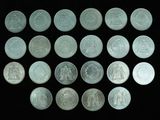 some silver coins are arranged in a row on a black surface