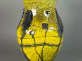 a yellow vase with black and white designs on it