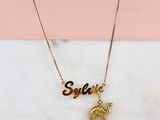 un collier plaqué or orné d'un éléphant et d'une plaque portant un prénom
