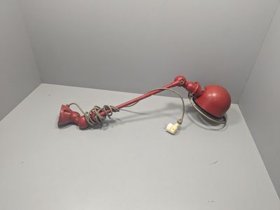 une lampe rouge posée sur une table blanche