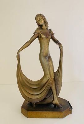 bronze statue of a woman with a flowing dress on a base