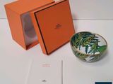 une boîte orange contenant un petit bol, posée sur une table