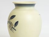 a white vase with a black design on it