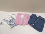 trois paires de jeans et un pull posés sur une table