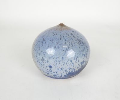 un vase bleu et blanc posé sur une surface blanche