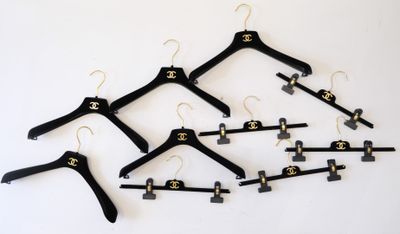 cinq cintres noirs sur lesquels est accroché un lustre