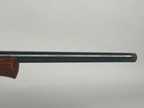 a close up of a shotgun with a wooden barrel on it