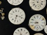 many different types of clocks displayed on a black surface