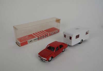 une petite voiture et une petite remorque posées sur une surface blanche