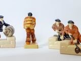 trois figurines représentant des hommes assis sur un banc