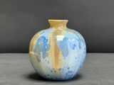 un vase bleu et jaune posé sur une table
