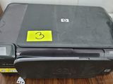 a printer sitting on a table with a yellow sticker on it