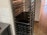 une étagère métallique avec des plateaux de nourriture dans une cuisine