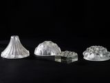 three pieces of glass sitting on a black surface