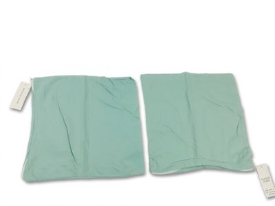 deux morceaux de tissu vert posés l'un à côté de l'autre sur une surface blanche