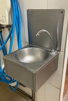 un évier en inox avec un tuyau bleu à côté