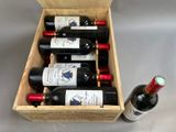 bottles of wine are in a wooden box on a table