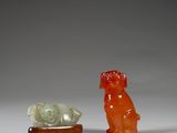 two small figurines of animals and a fish on a table