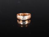un gros plan d'une bague en or sertie d'un diamant sur un fond noir