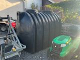 a large black tank sitting next to a green lawn mower