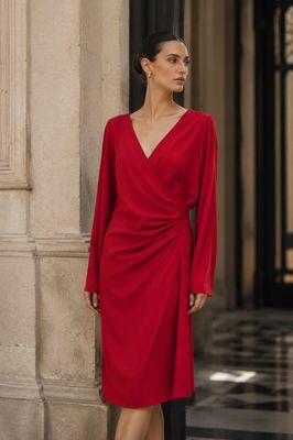 the woman in the red dress is posing for the camera