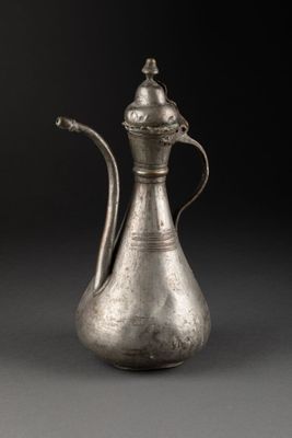 une vieille cafetière en argent avec une poignée et une poignée