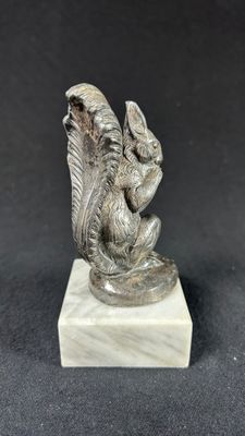 an image of a statue of a bird sitting on top of a marble block