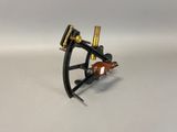 a close up of a black and gold tattoo machine on a white surface