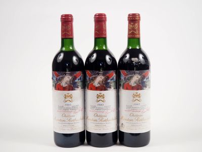 trois bouteilles de vin rouge posées l'une à côté de l'autre sur une surface blanche