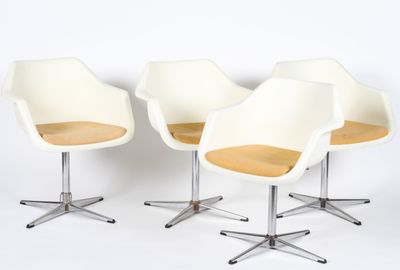 three white chairs sitting on top of each other in front of a white wall