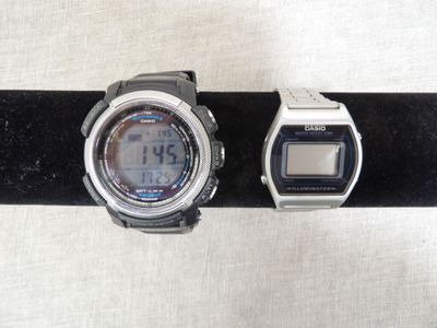 two watches sitting on a black band on a table