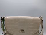 the small white purse is sitting on a white surface