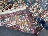 a person standing next to a large rug on the ground