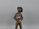 bronze figurine of a boy with a hat on his head