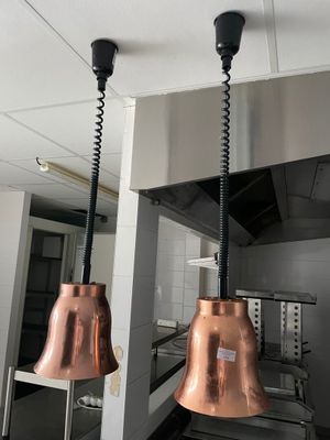 deux clochettes en cuivre suspendues au plafond de la cuisine