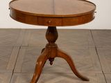 une table ronde avec un plateau en bois posée sur un parquet