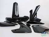 quatre morceaux de plastique noir posés sur une table blanche