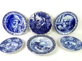several blue and white plates with pictures of people and animals on them