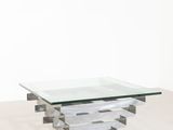 une table basse en verre et chrome avec un plateau carré en verre