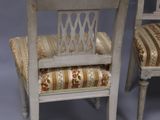 pair of antique chairs with upholstered cushions on a grey background