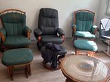 plusieurs chaises et une table dans un salon où est accroché un tableau au mur