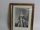 une vieille photo d'une femme en robe est accrochée au mur