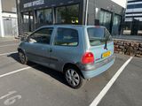 une petite voiture garée sur un parking devant un immeuble