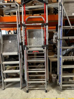 many ladders that are stacked up in a warehouse