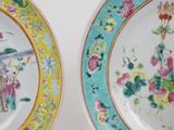 two plates with asian designs on them on a table